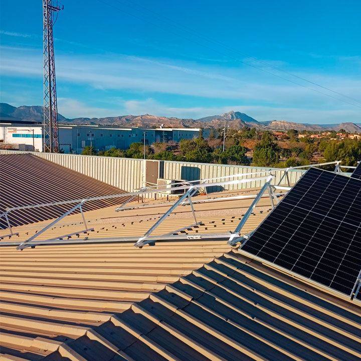 Placas solares instaladas sobre estructura de aluminio en el tejado de una nave industrial (Vertical)