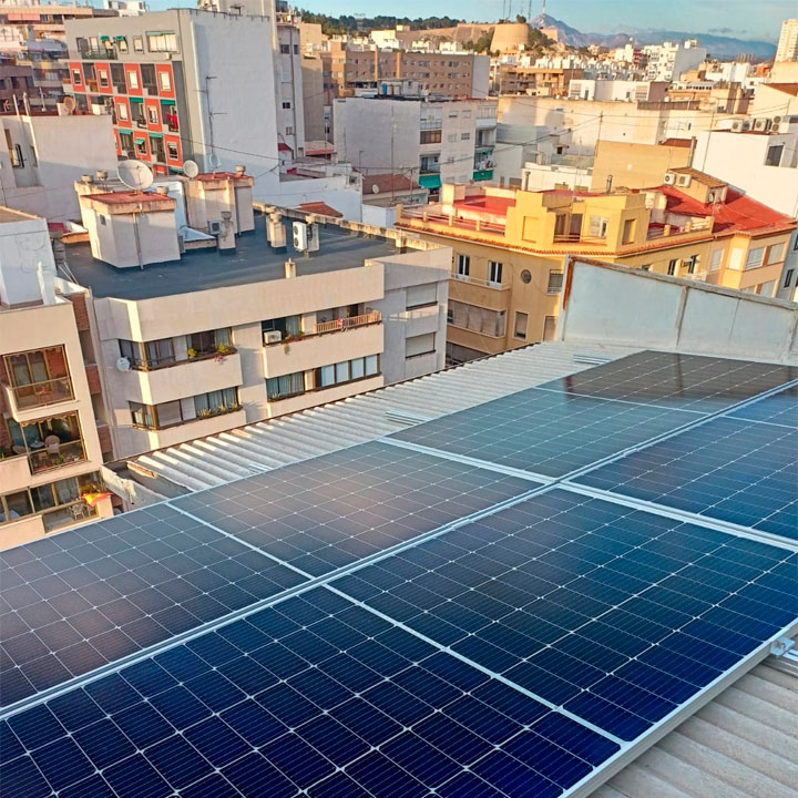 Placas solares instaladas sobre el tejado de un edificio residencial (Vertical)